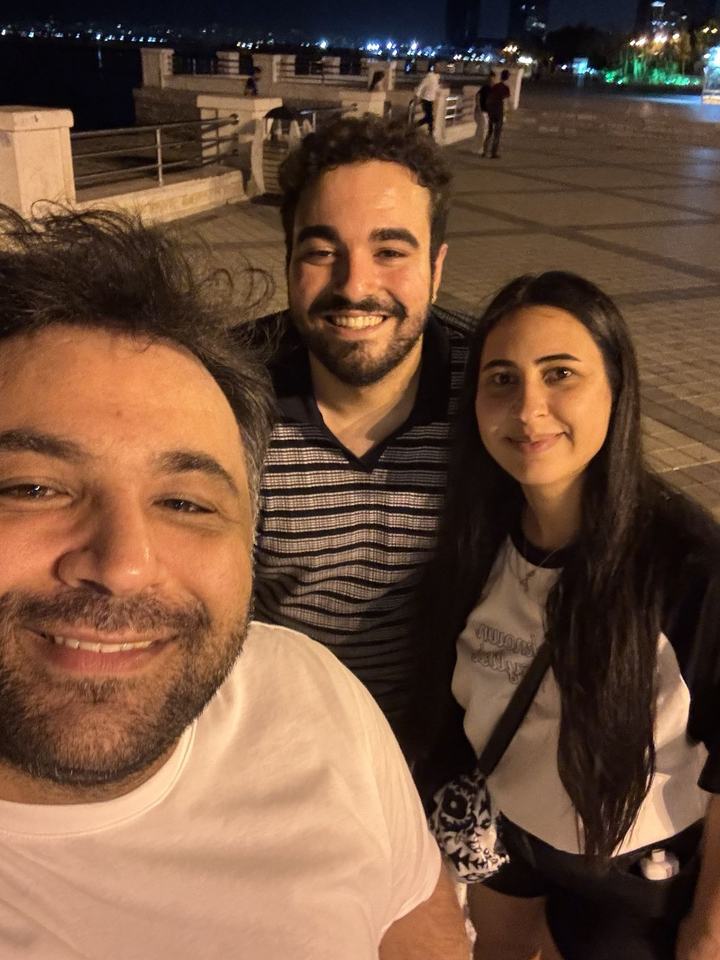Recep, gece sahilde gülümseyerek selfie çekiyor